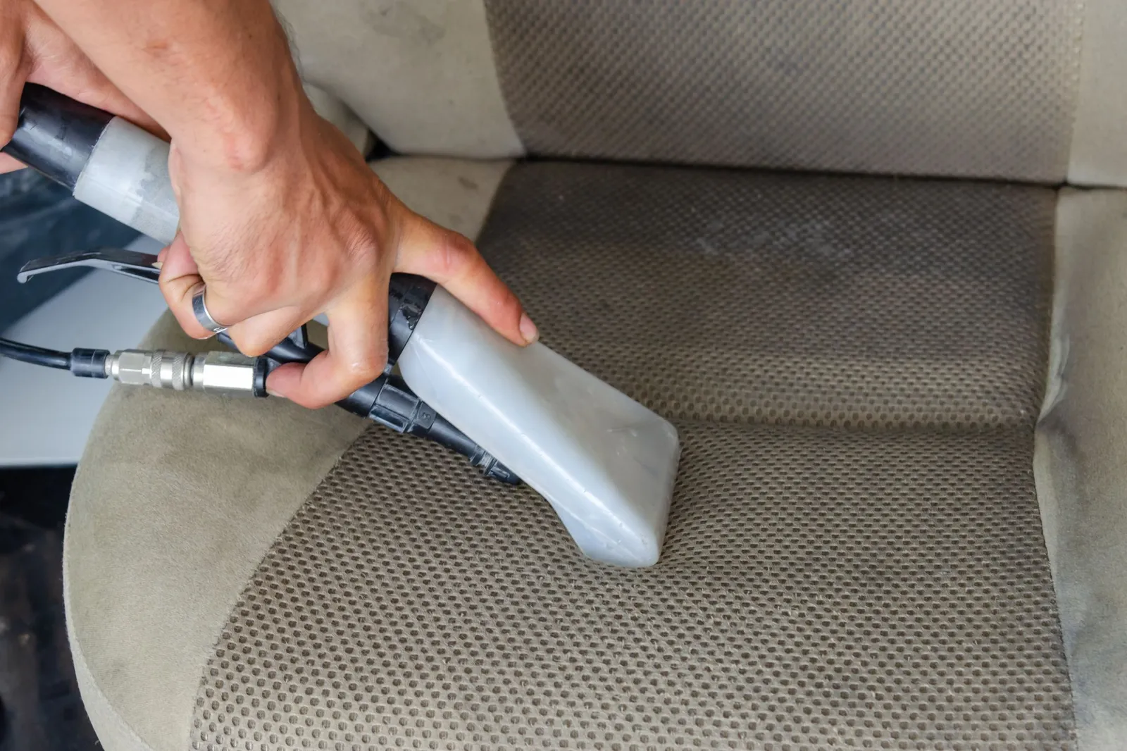 Limpeza de estofos com máquina de extração no interior de um carro